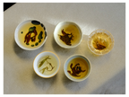 2026 Discovery Collection tasting: five small cups of brewed loose leaf tea on linen, from pale green leaves to dark twisted leaves in amber liquor