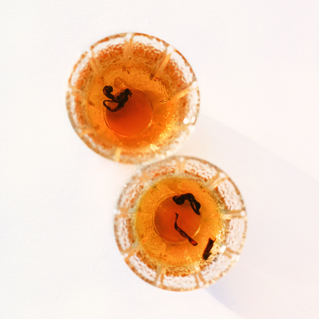 Himalayan Golden Black and Rare Red Oolong side by side, brewed in glass tea cups