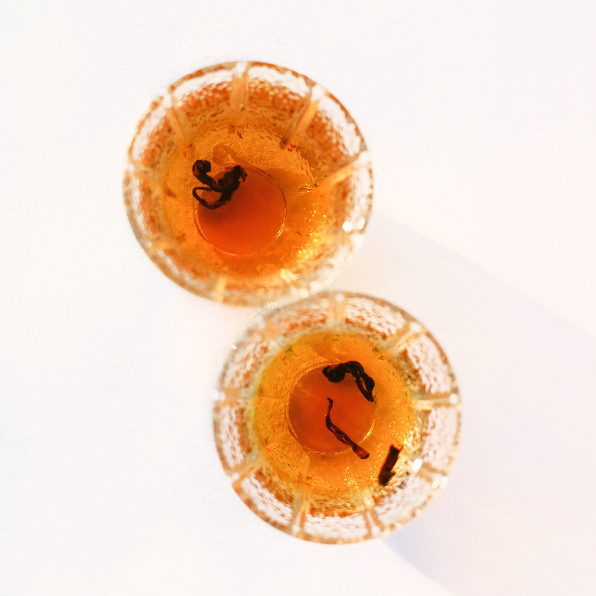 Himalayan Golden Black and Rare Red Oolong side by side, brewed in glass tea cups